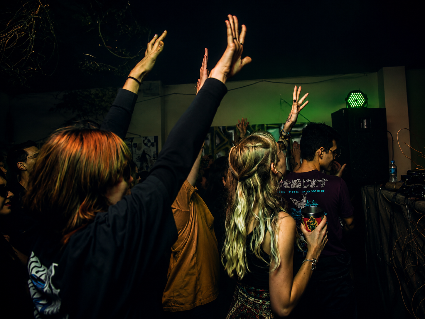 Público dançando em uma festa com pouca luz