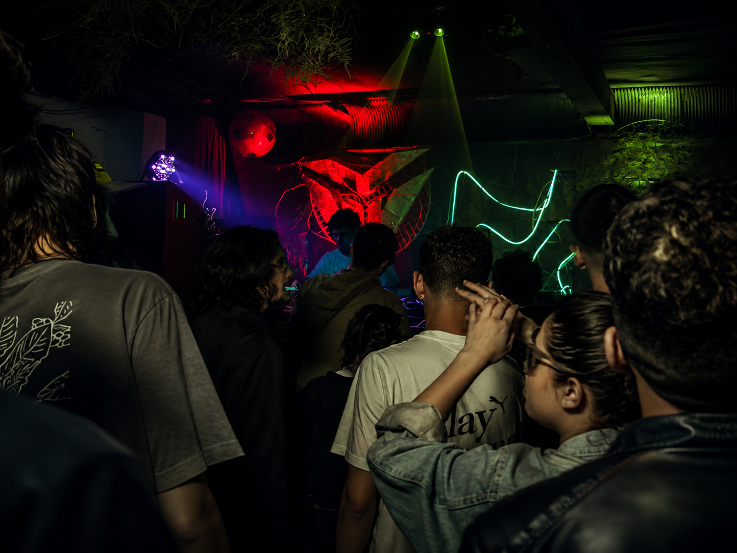 Luzes neon e público em clima de música eletrônica